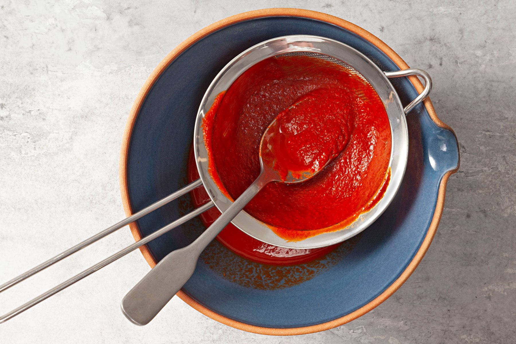 Straining the sauce through mesh strainer