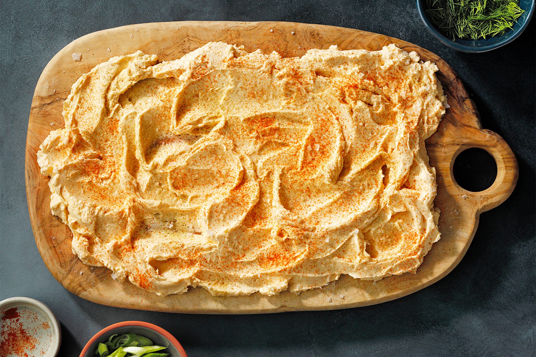 A wooden platter with Herbed Butter on it