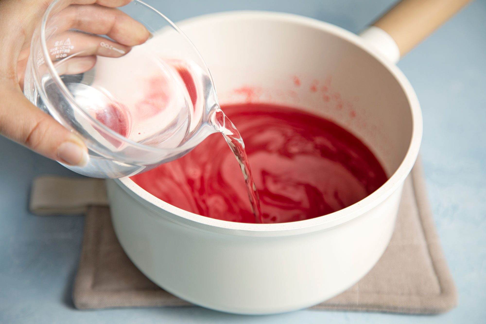 close shot of vodka added in the cherry gelatin mix