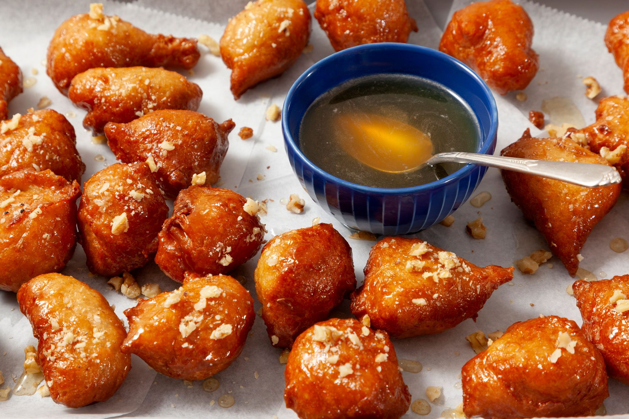 Garnished Loukoumades (Greek Doughnuts) with crushed Nuts and honey