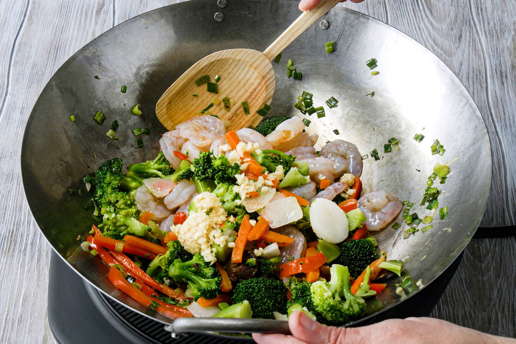 Add the shrimp, the vegetable blend, and the minced garlic in the skillet