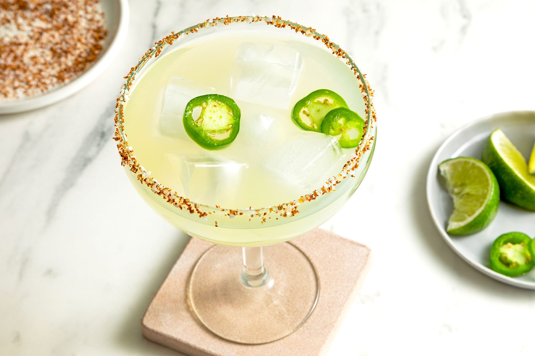 wide shot of glass of spicy margarita garnished with jalapeno slices