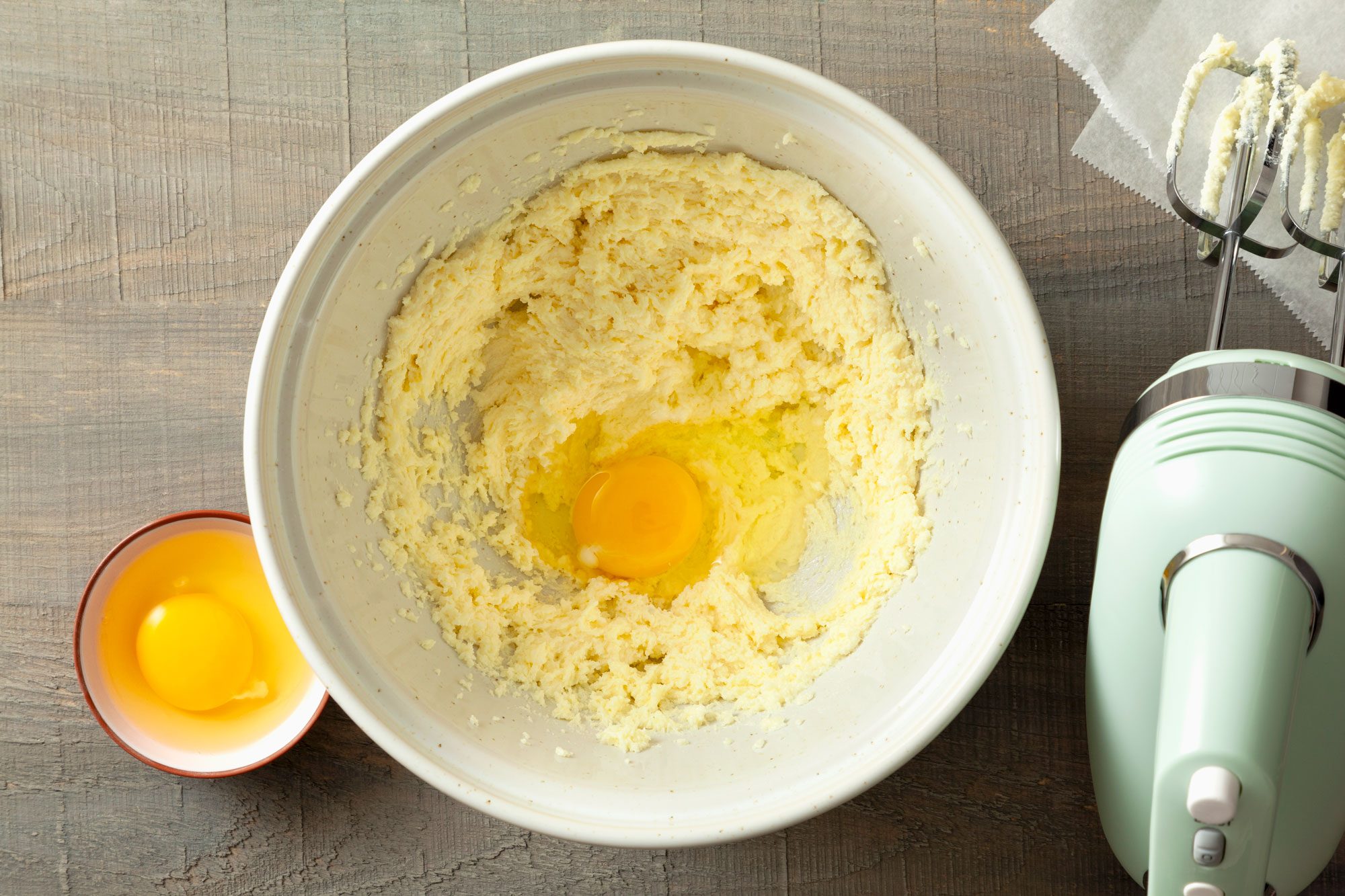 egg and butter-sugar mixture in a large bowl on a wooden surface