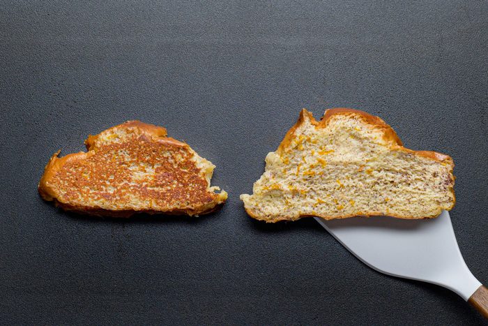 overhead shot; black background; cooking breads; on griddle; spatula;