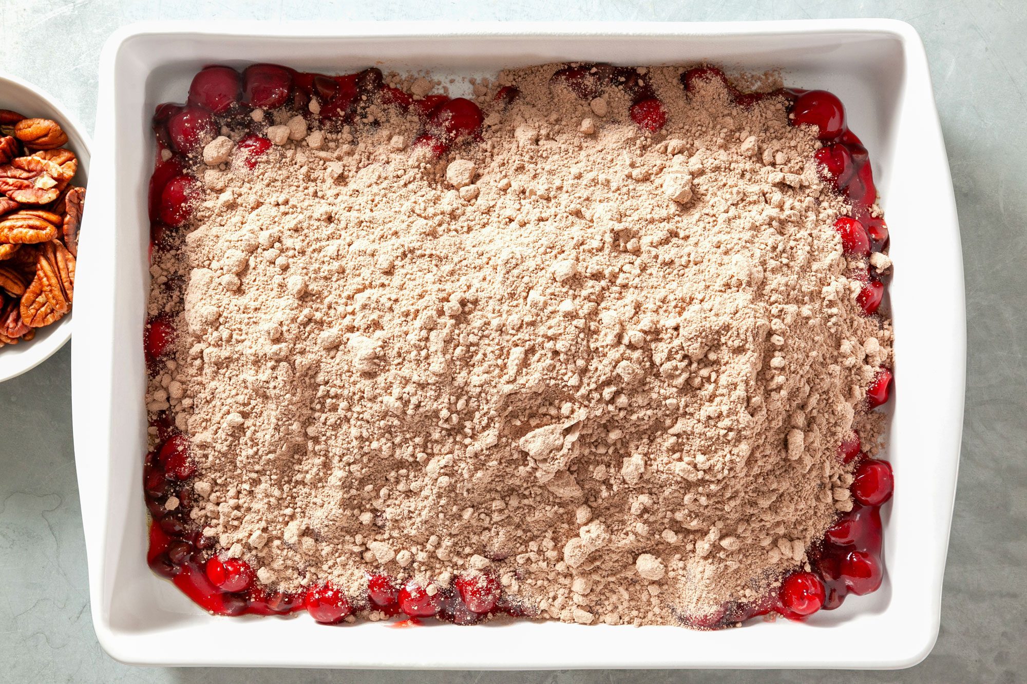 Overhead shot of cake mix spread in a greased baking dish