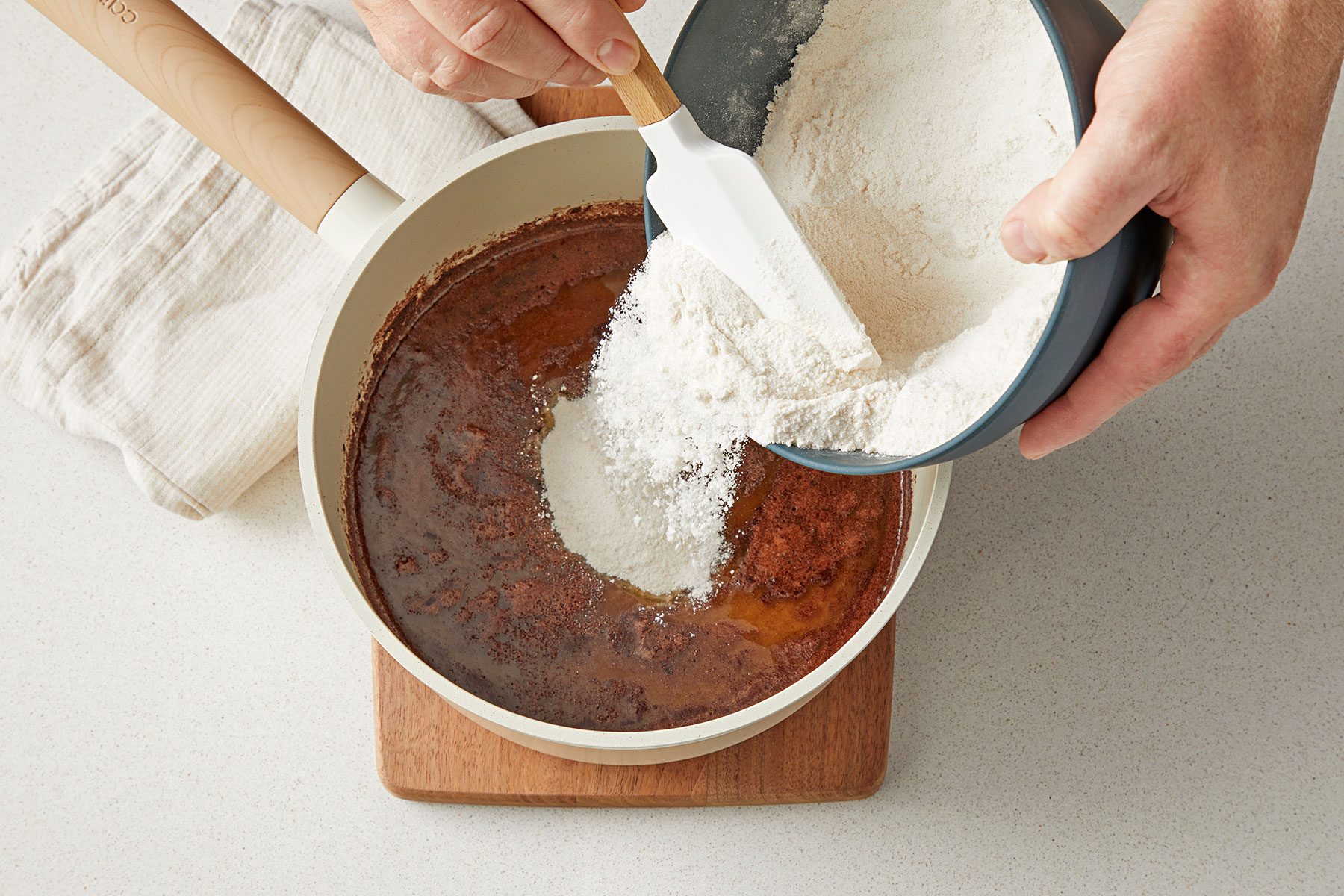 overhead shot of flour added in the mix in a saucepan