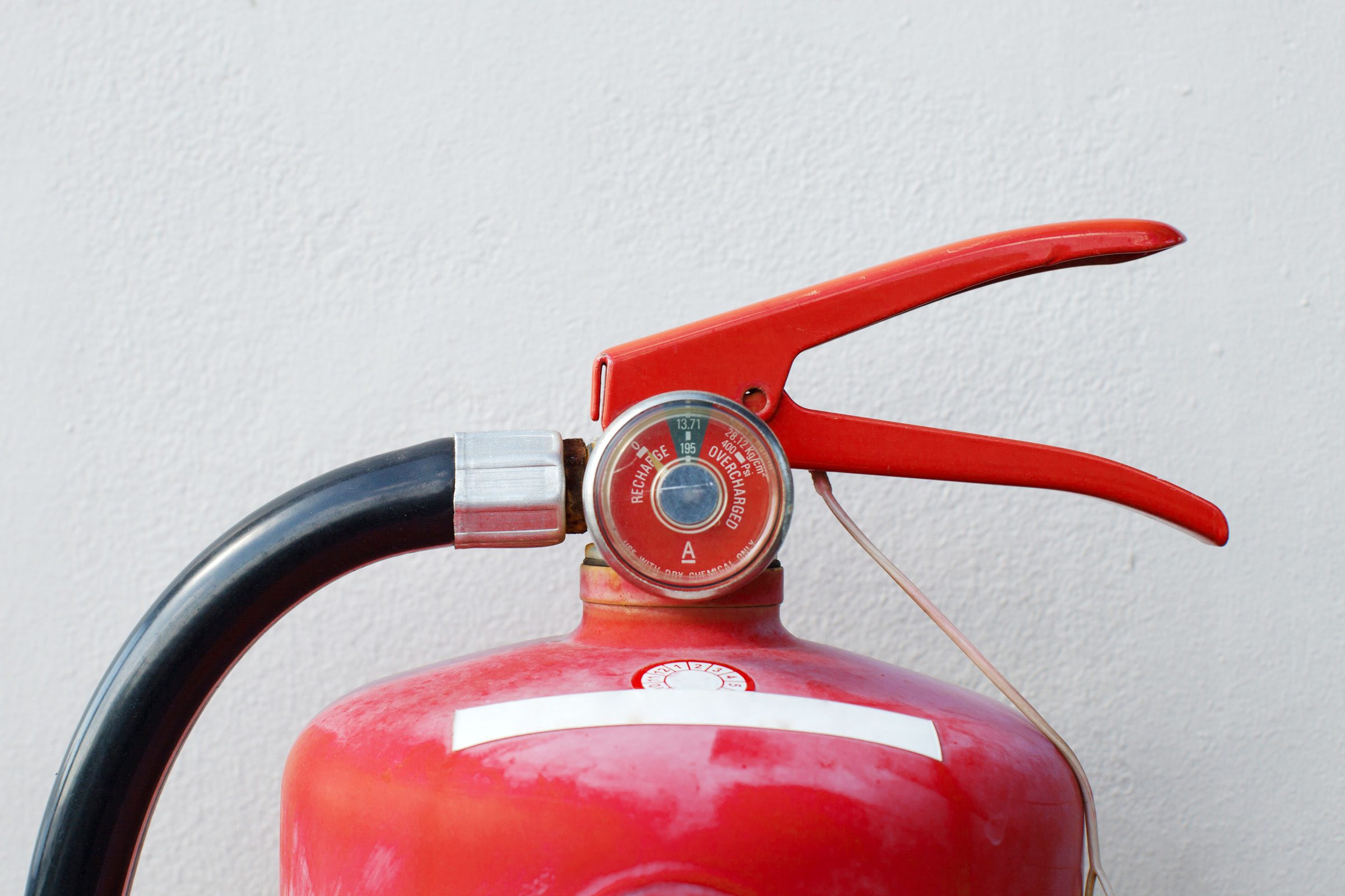 fire extinguisher outside against a patio wall for grilling