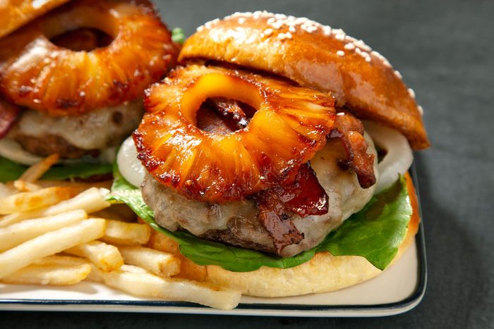close shot; horizontal shot; Hawaiian Burgers served with fries in a plate;