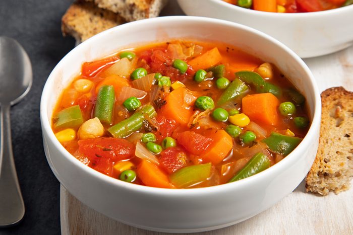 A bowl of Hearty Vegetable Soup on a wooden table