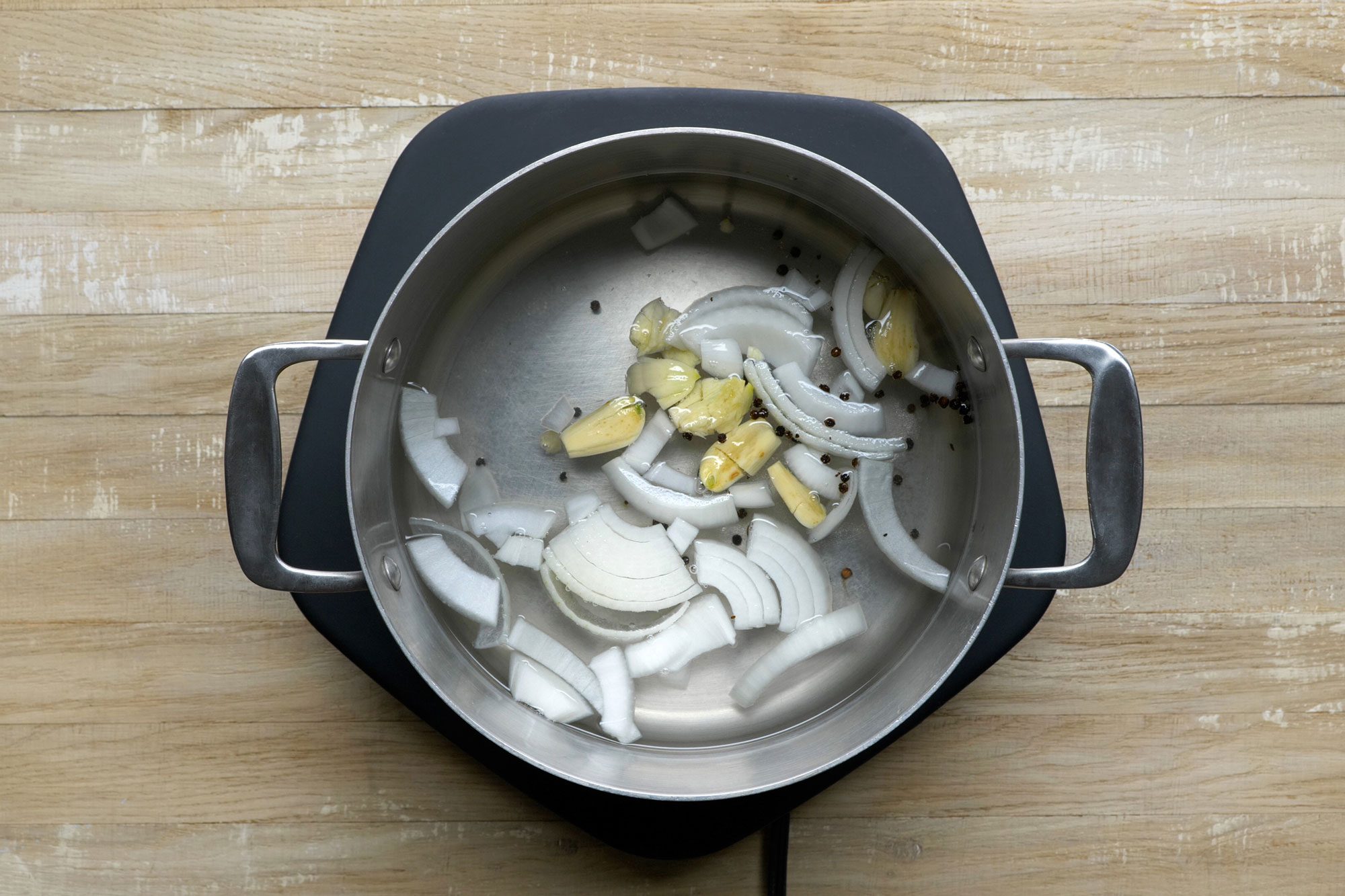 Combine white onion slices, garlic, 2 teaspoons of salt and peppercorns with water in a large saucepan