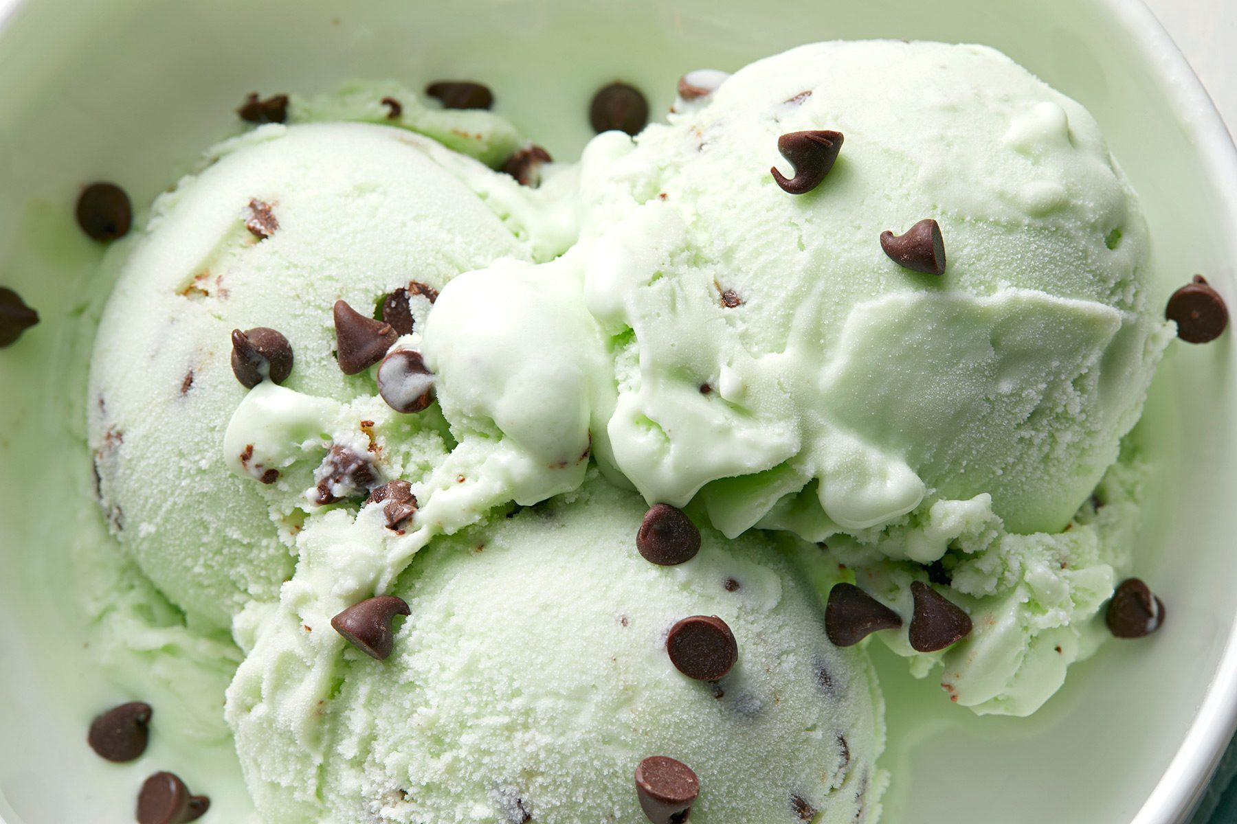 overhead shot; close shot; white background; Mint Chocolate Chip Ice Cream served in a small bowl