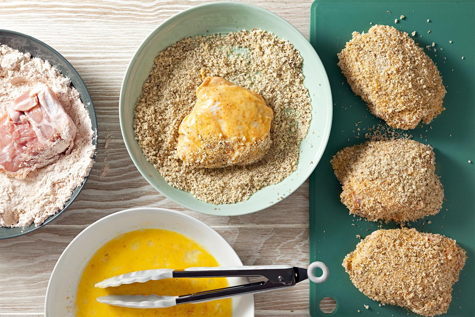 In a shallow bowl, mix bread crumbs, Parmesan cheese and Italian seasoning, In another shallow bowl, mix flour, cornstarch, seafood seasoning, garlic powder, salt and pepper, Whisk eggs and milk in a third shallow bowl, Dipped chicken in flour to coat both sides