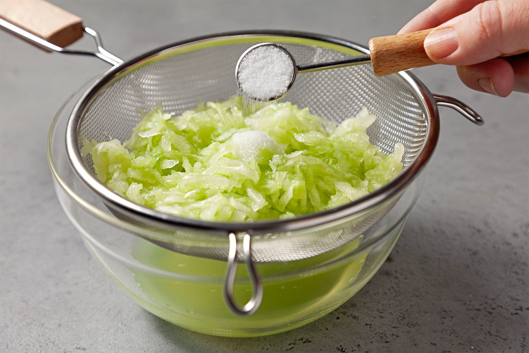 cucumber in a fine mesh strainer over a bowl; sprinkled with tablespoon salt