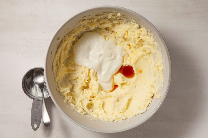 Overhead shot of bowl; beat in yogurt and vanilla; spoons; marble background;