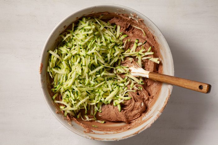 Overhead shot of bowl; stir in zucchini.; spatula; marble background