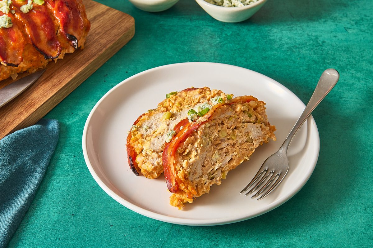 Closeup of two slices of buffalo chicken meatloaf on a plate with a fork