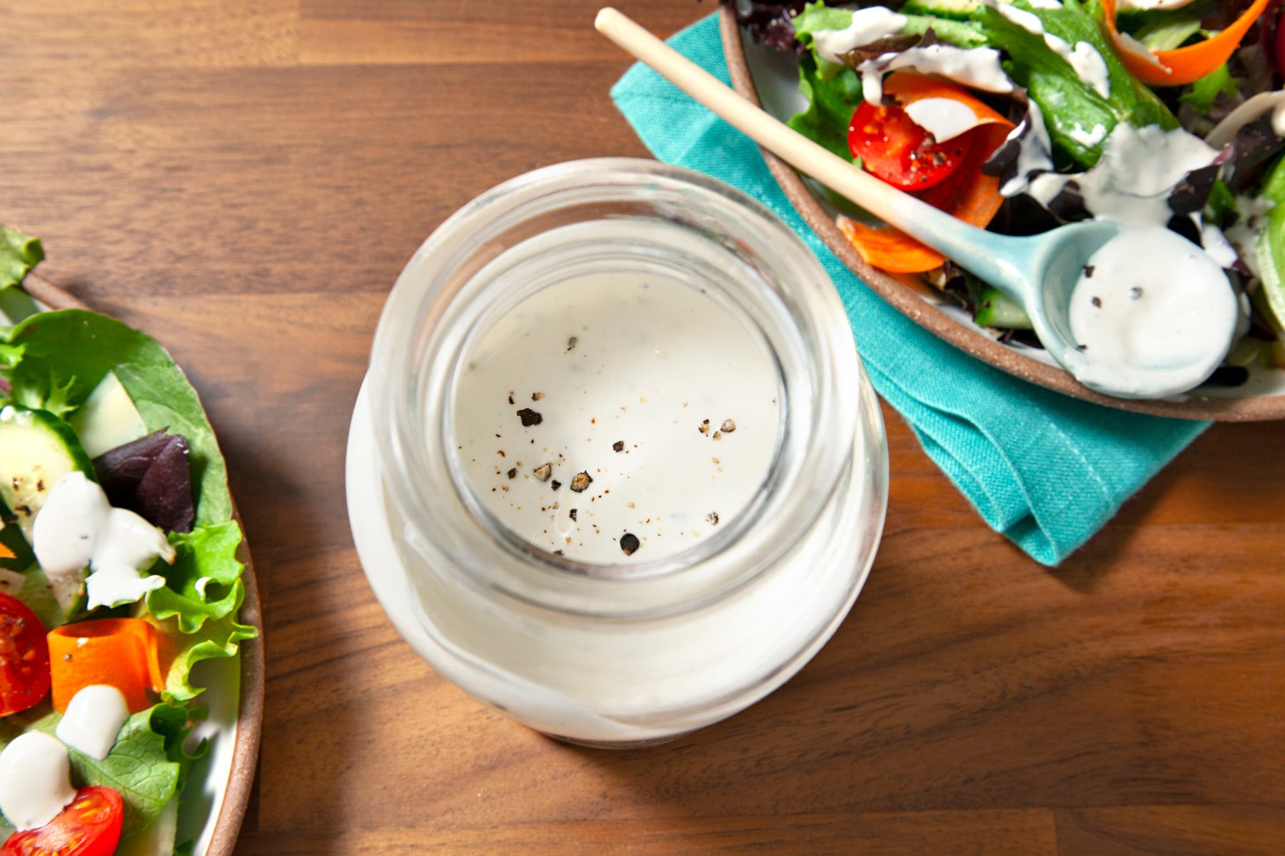 A Jar of Creamy Peppercorn Dressing on a wooden table