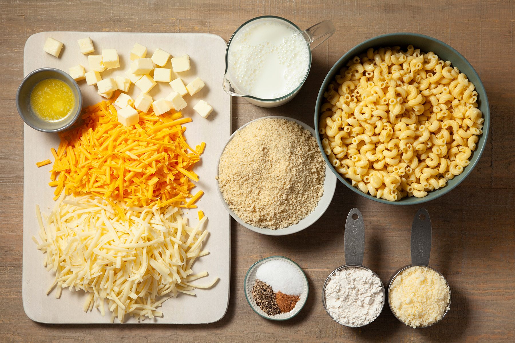 overhead shot; wooden background; Baked Three-Cheese Macaroni ingredients placed over background;