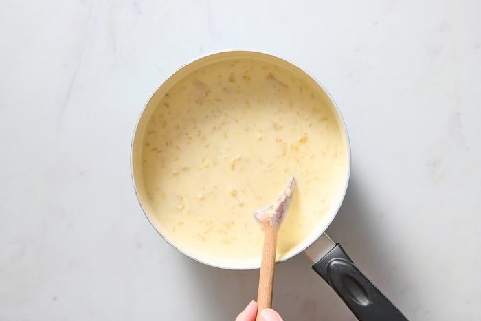 Stirring pineapple into the cooled milk mixture