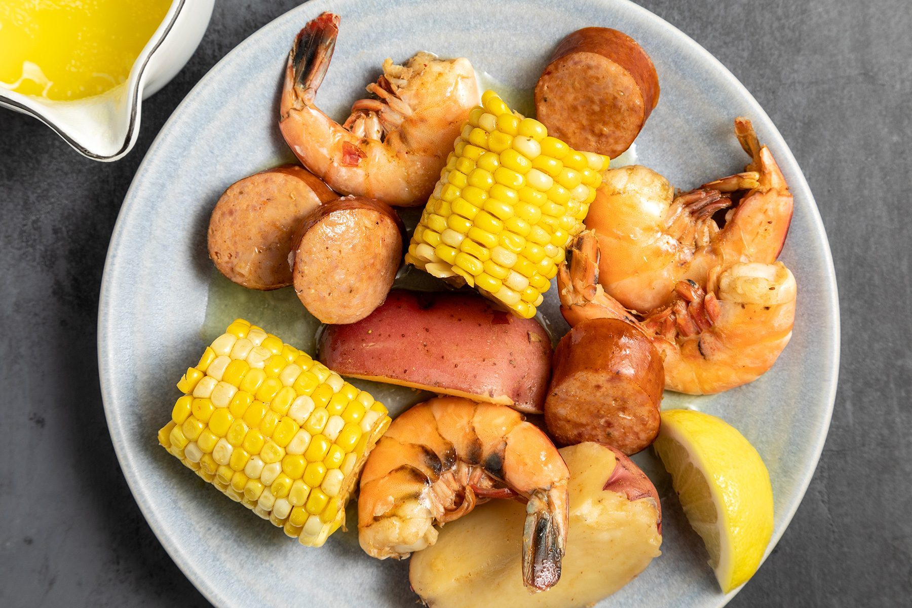 overhead shot of shrimp boil served with melted butter