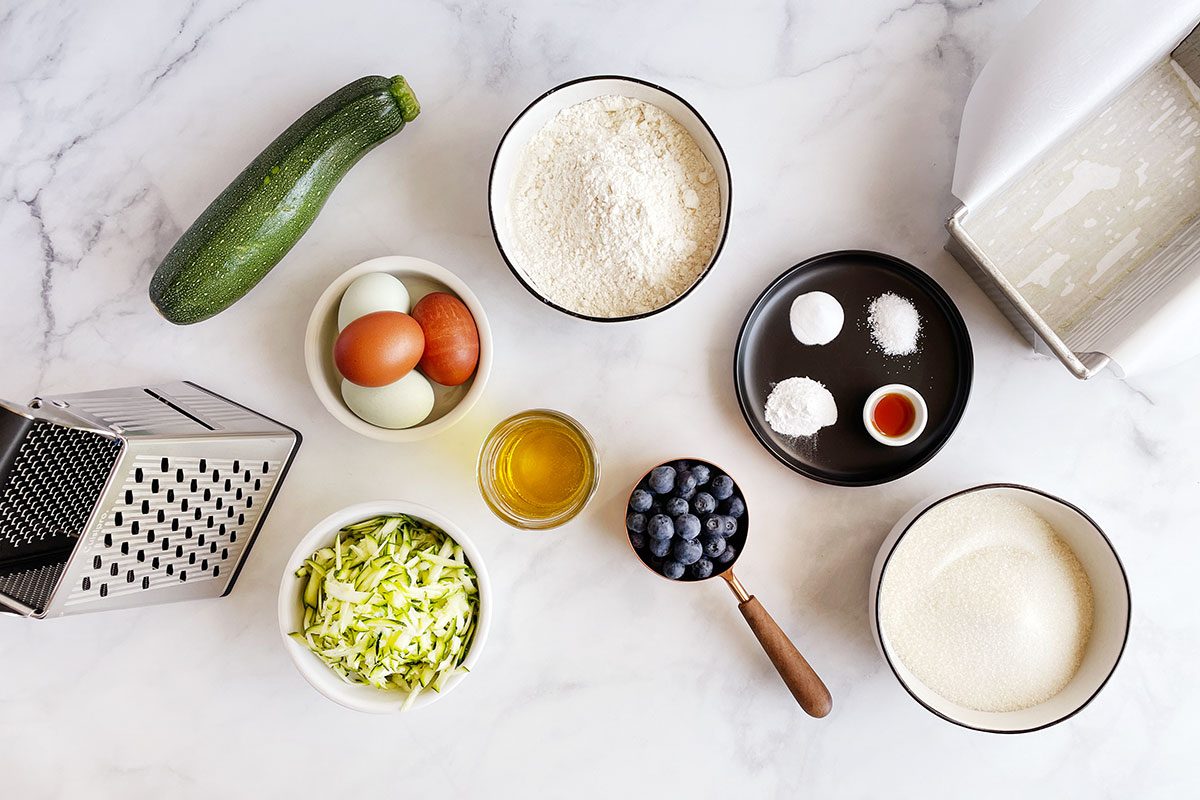 Ingredients for Taste of Home's Blueberry Zucchini Bread on a white marble table