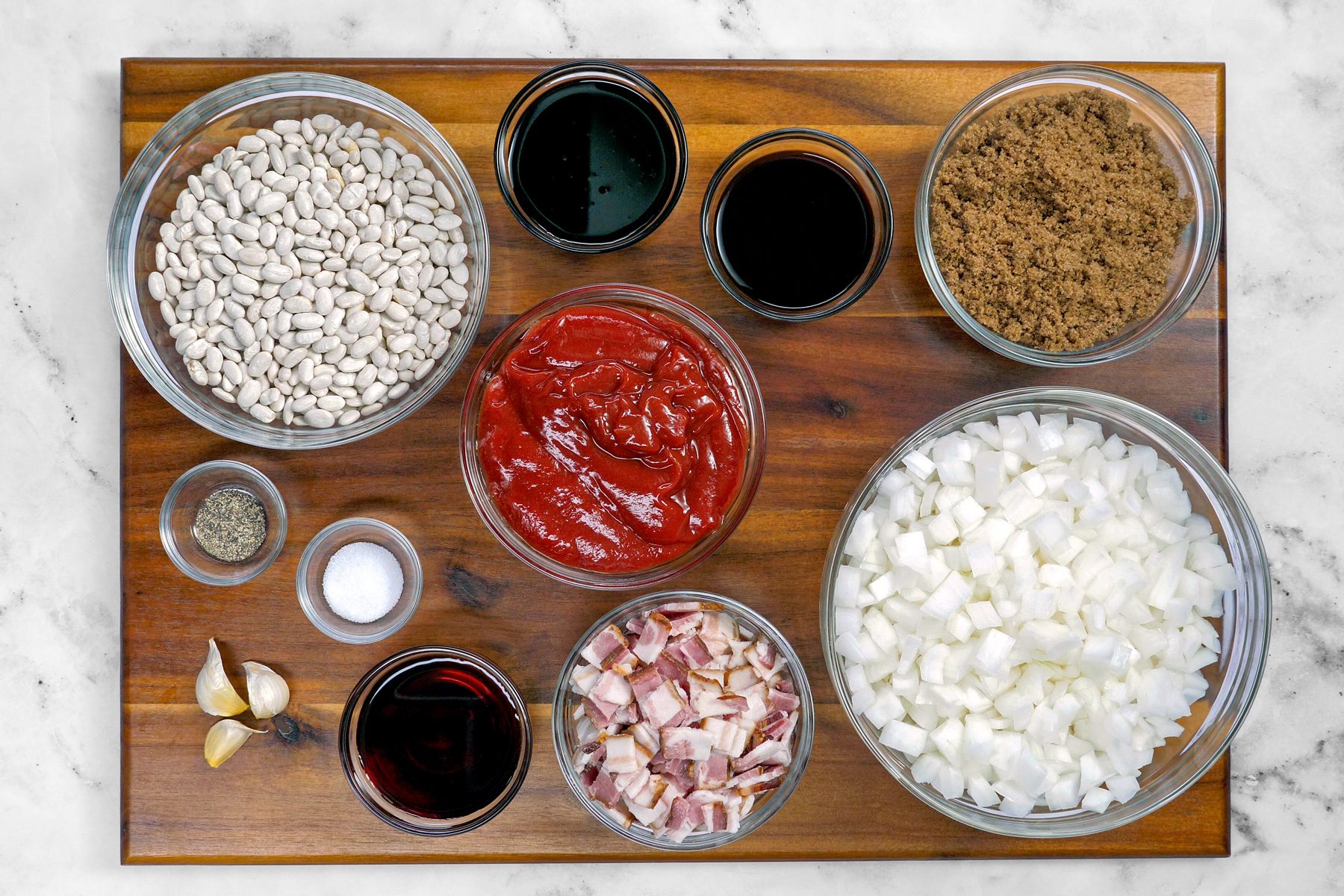 Top shot of ingredients for boston baked beans on wooden board