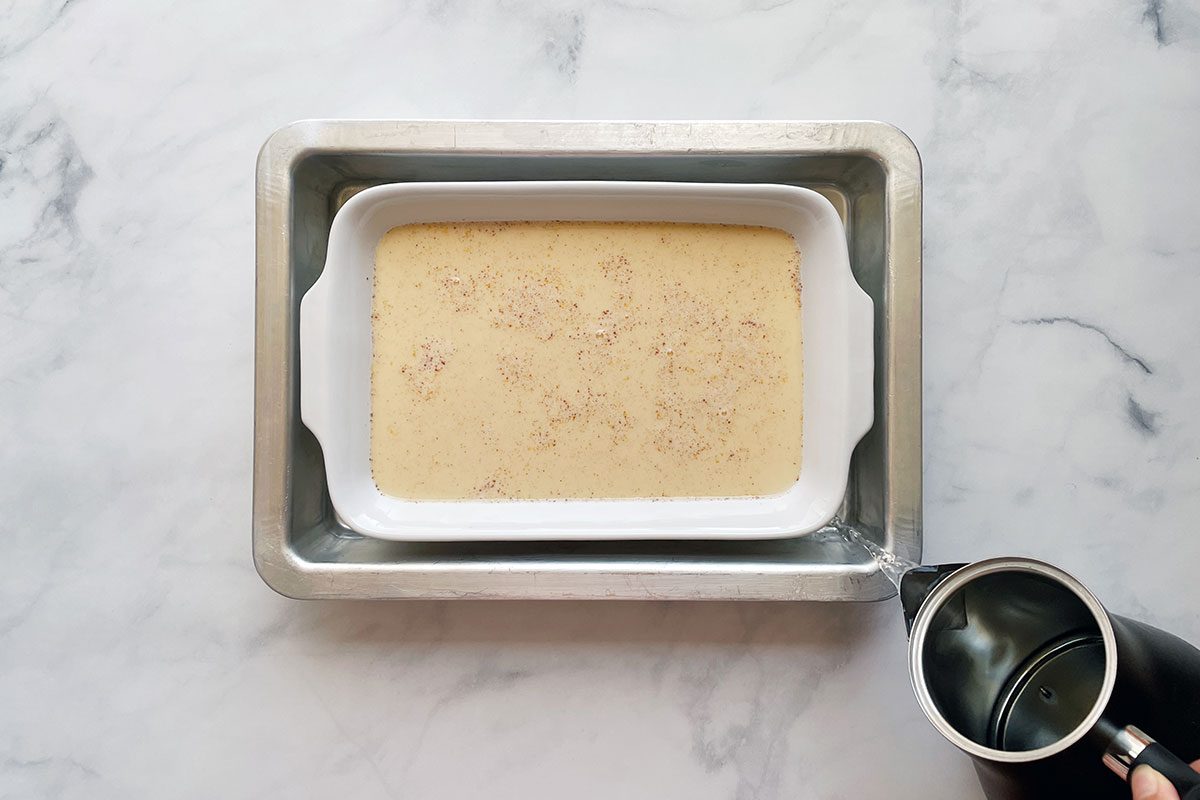 How to make Taste of Home's Baked Egg Custard, step 2 is pouring the custard mixture in a baking dish in a water bath