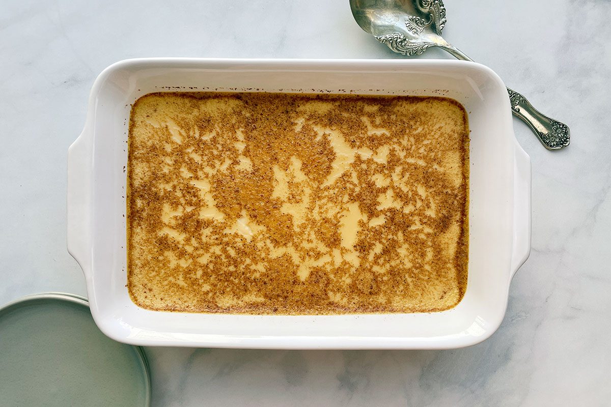 Overhead shot of Taste of Home's Baked Egg Custard in a serving dish on a white marble background