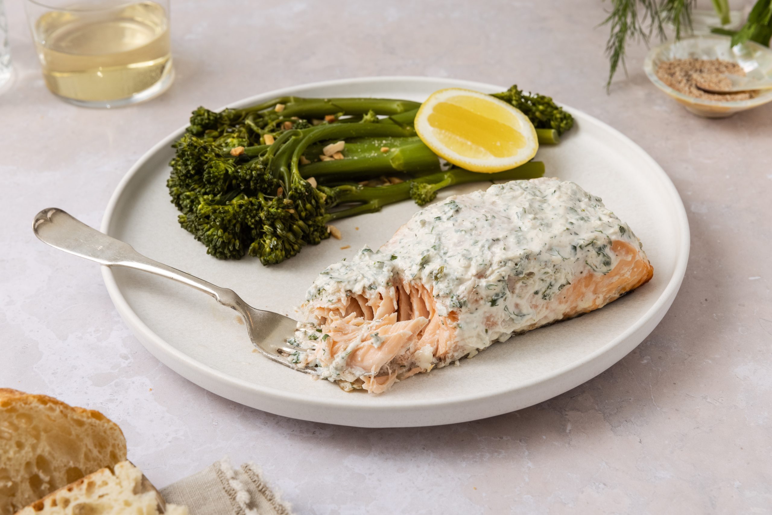 Herb grilled salmon served on plate with a piece of salmon on the fork. 