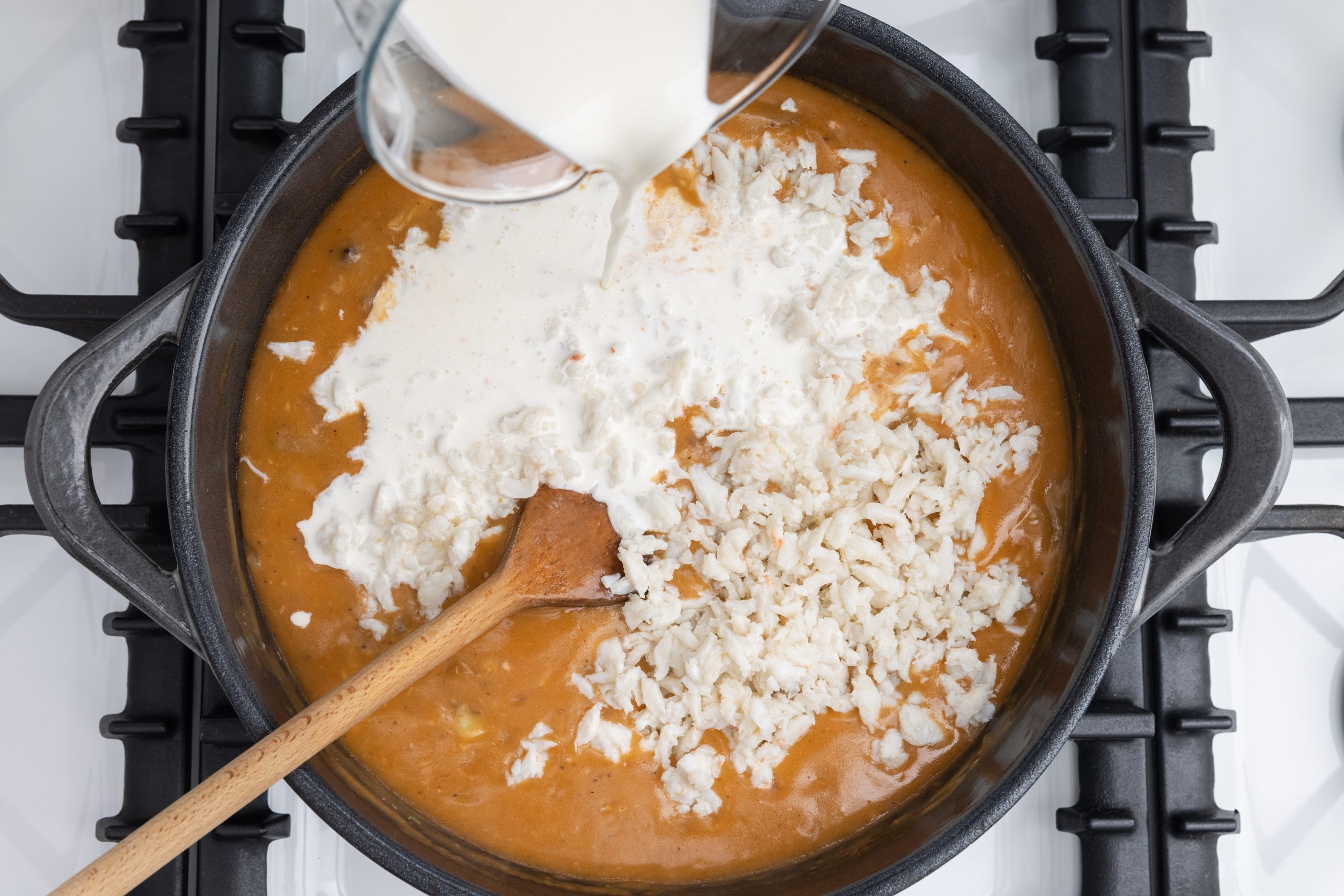 Adding crab meat and heavy whipping cream to the bisque.