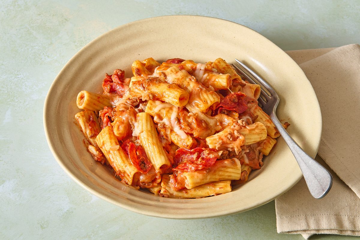 Slow cooker pizza casserole served in a bowl plate with a fork