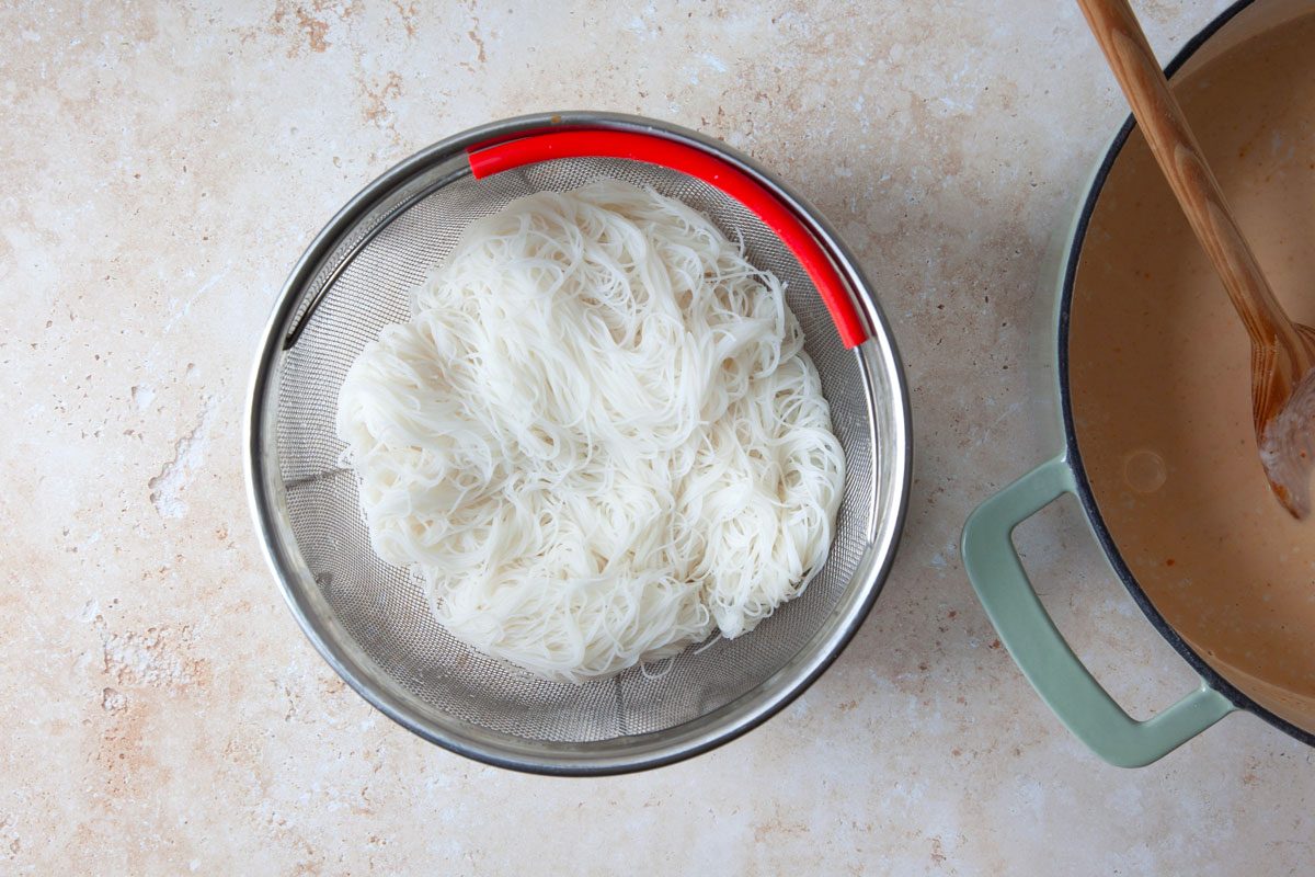 cooked and drained rice noodles in a colander