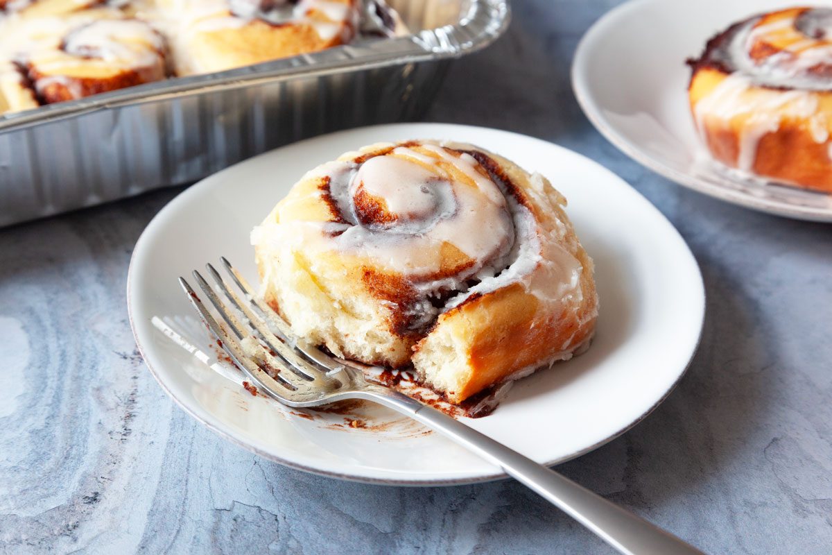 Single srevings of Taste of Home Amish Cinnamon Rolls on white plates