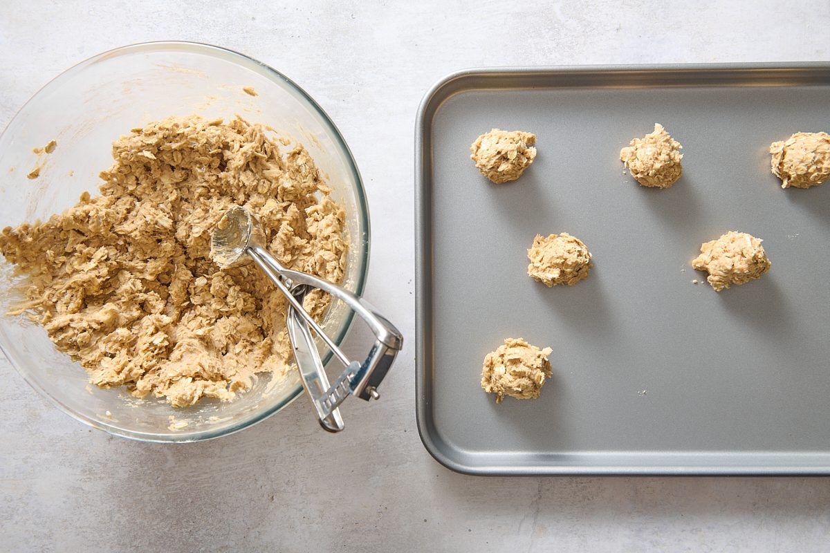 Scooping out spoonfuls of dough onto a baking sheet