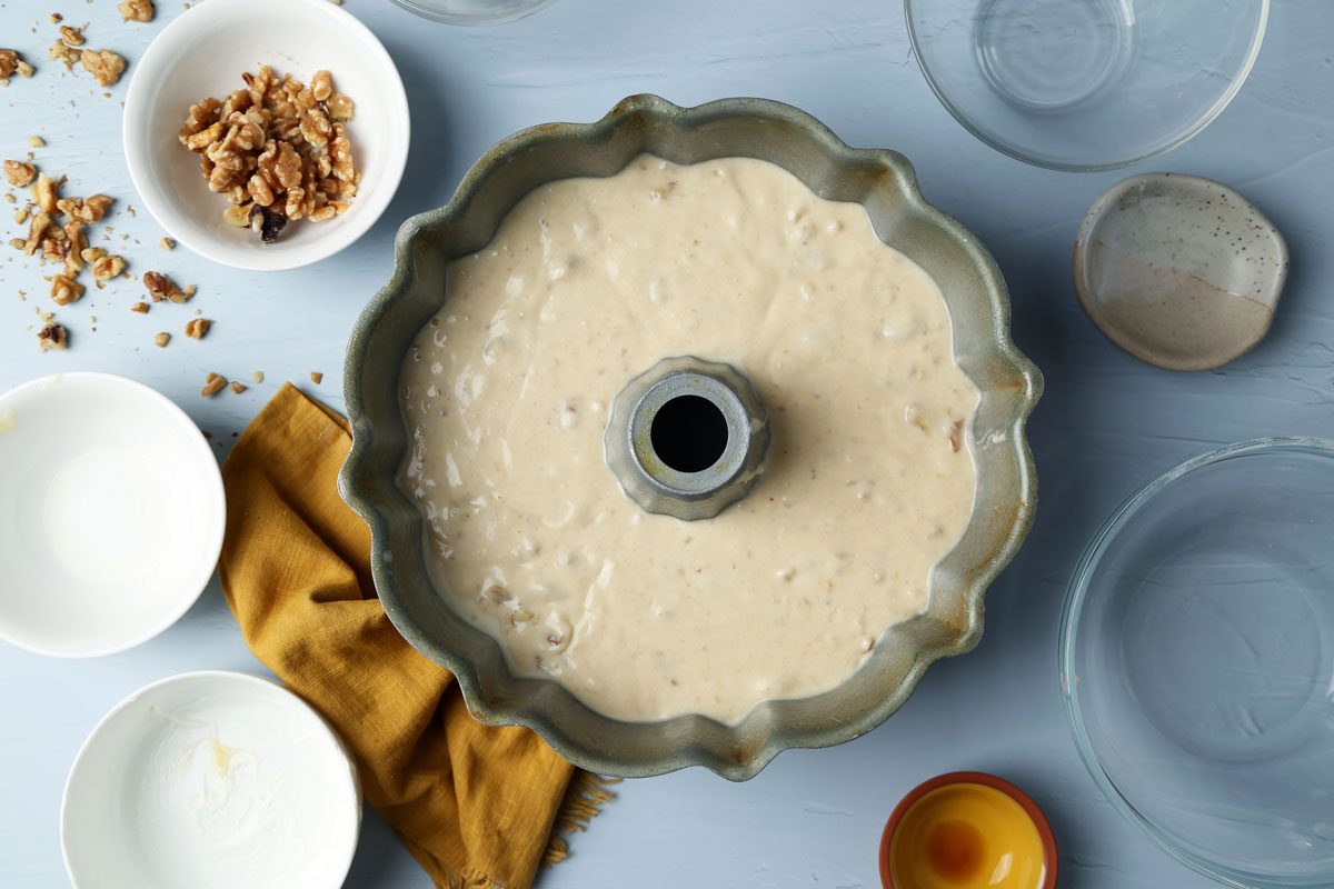 Close up of batter in a bundt pan for Taste of Home's Banana Bundt Cake on a blue surface.