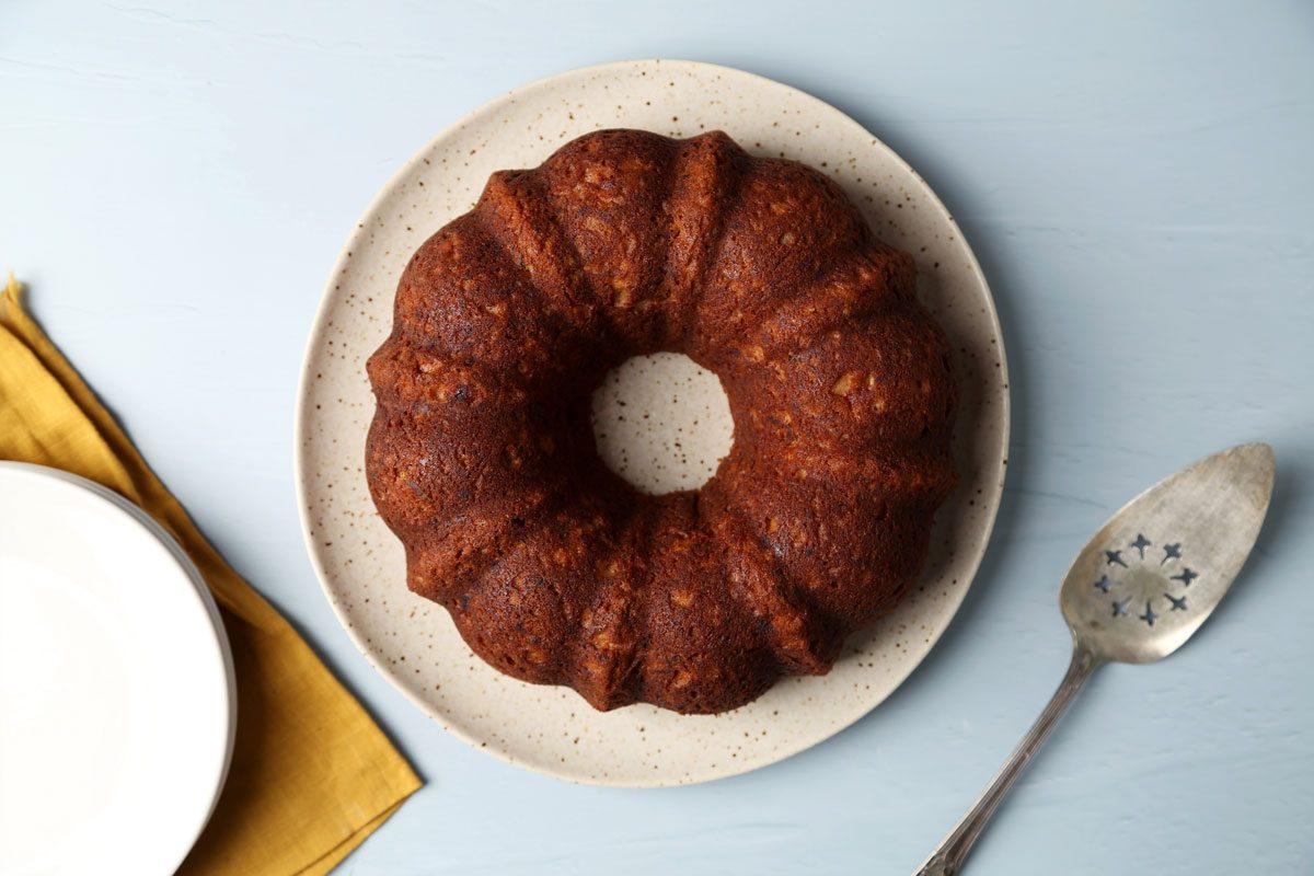 Taste of Home's Banana Bundt Cake sliced and served on a plate on a blue surface.