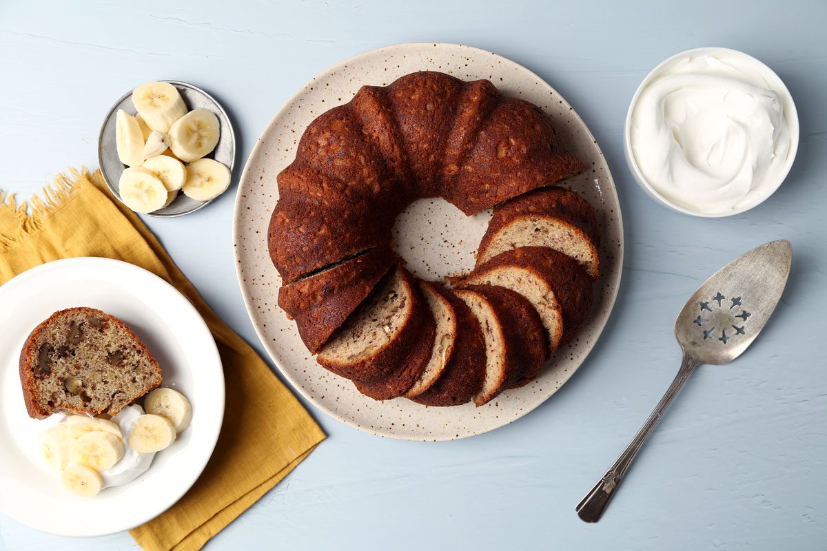 Taste of Home's Banana Bundt Cake sliced and served on a plate on a blue surface.