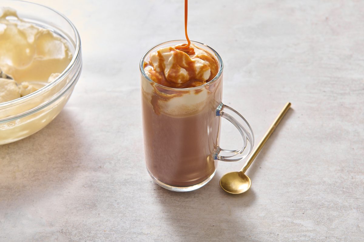 Drizzling caramel onto the cream-topped mocha