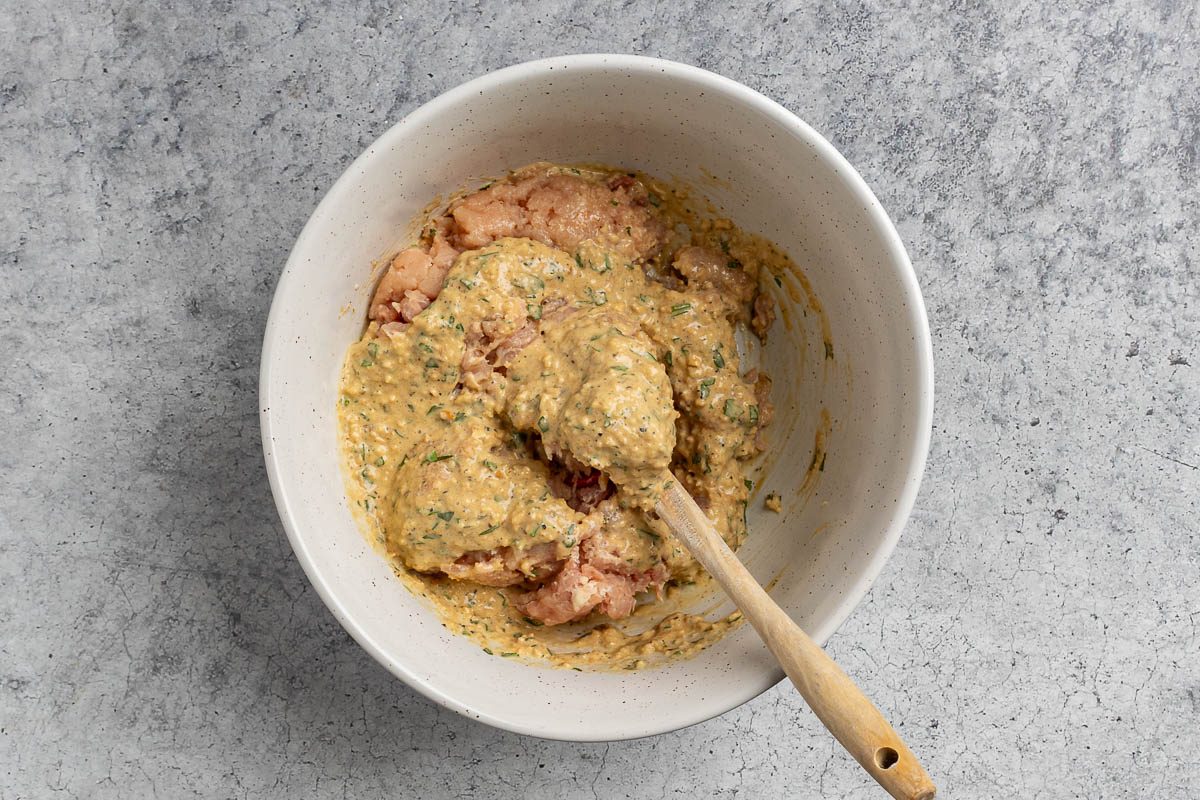 Taste of Home Chicken Loaf recipe photo of combining the chicken mixture with the ground chicken.