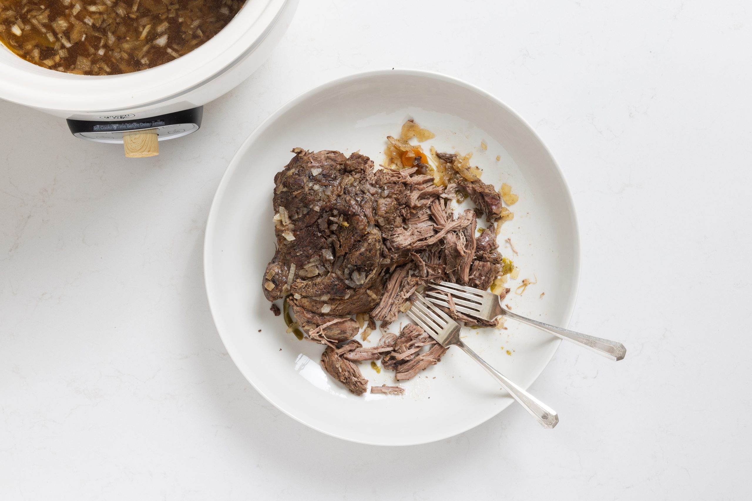 Roast being shredded with forks.