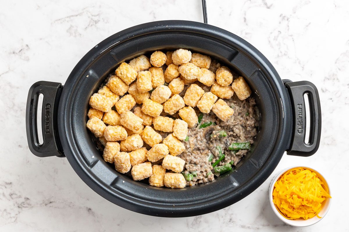 Taste of Home Crock Pot Tater Tot Casserole recipe photo of the casserole ingredients layered in a slow cooker.