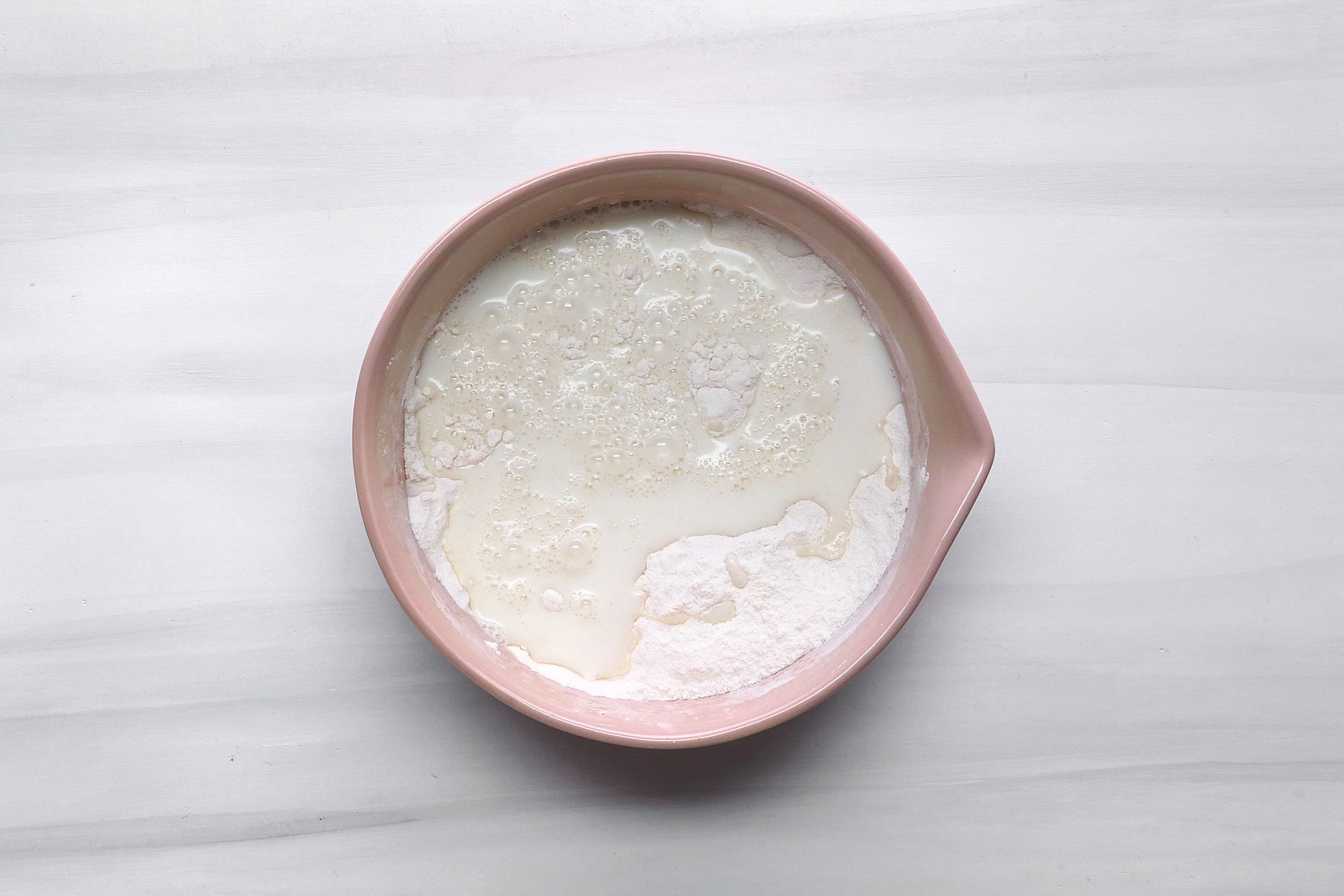 overhead shot; white background; in a bowl, combine 1 cup sugar, flour, baking powder and salt, Stir in milk;