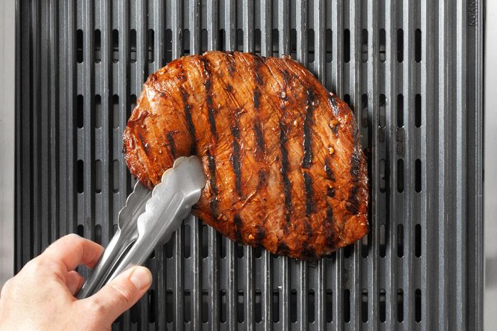 Turn over the grilled steak