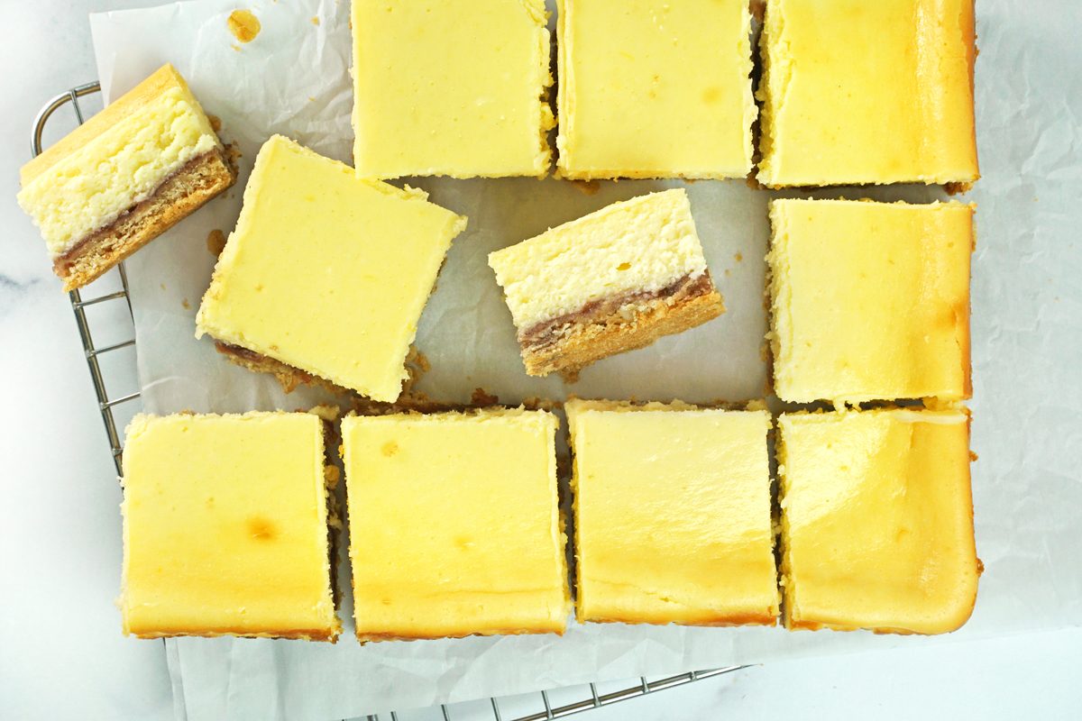 Taste of Home lemon cheesecake bars cut into bars on a cooling rack with parchment RMS 15811