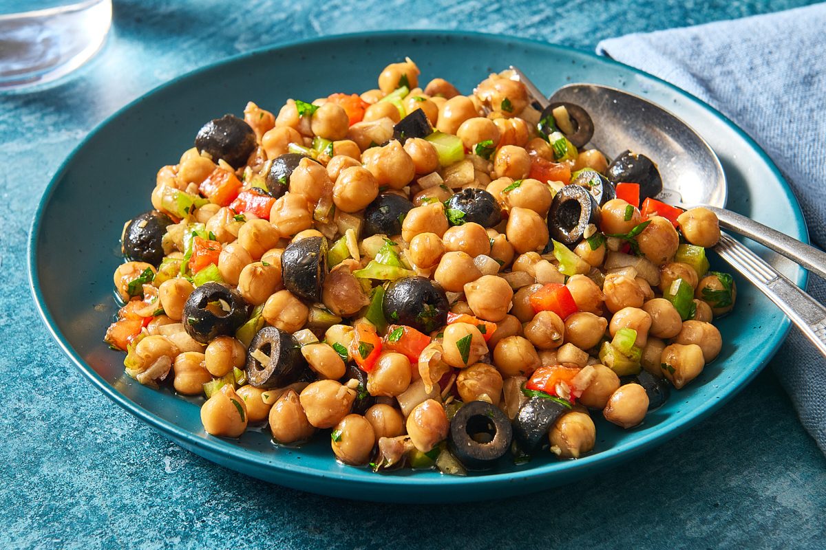 Closeup shot of Mediterranean chickpea salad on a plate with serving utensils