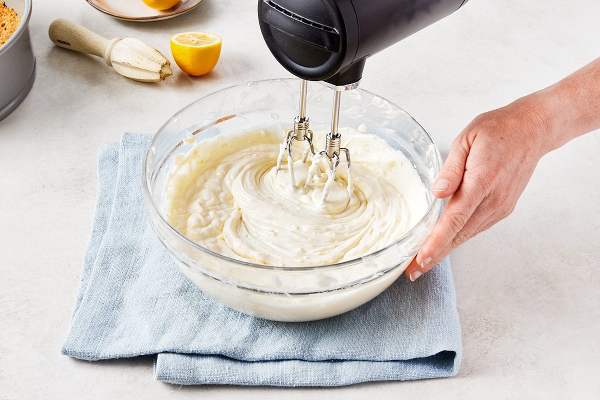 No Bake Lemon Cheesecake Step 2- mixing filling with an electric hand mixer