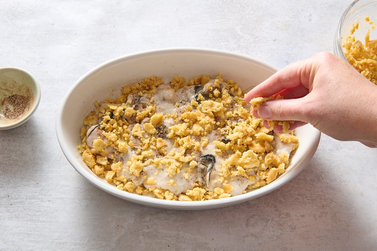 Sprinkling cracker topping over the oyster casserole
