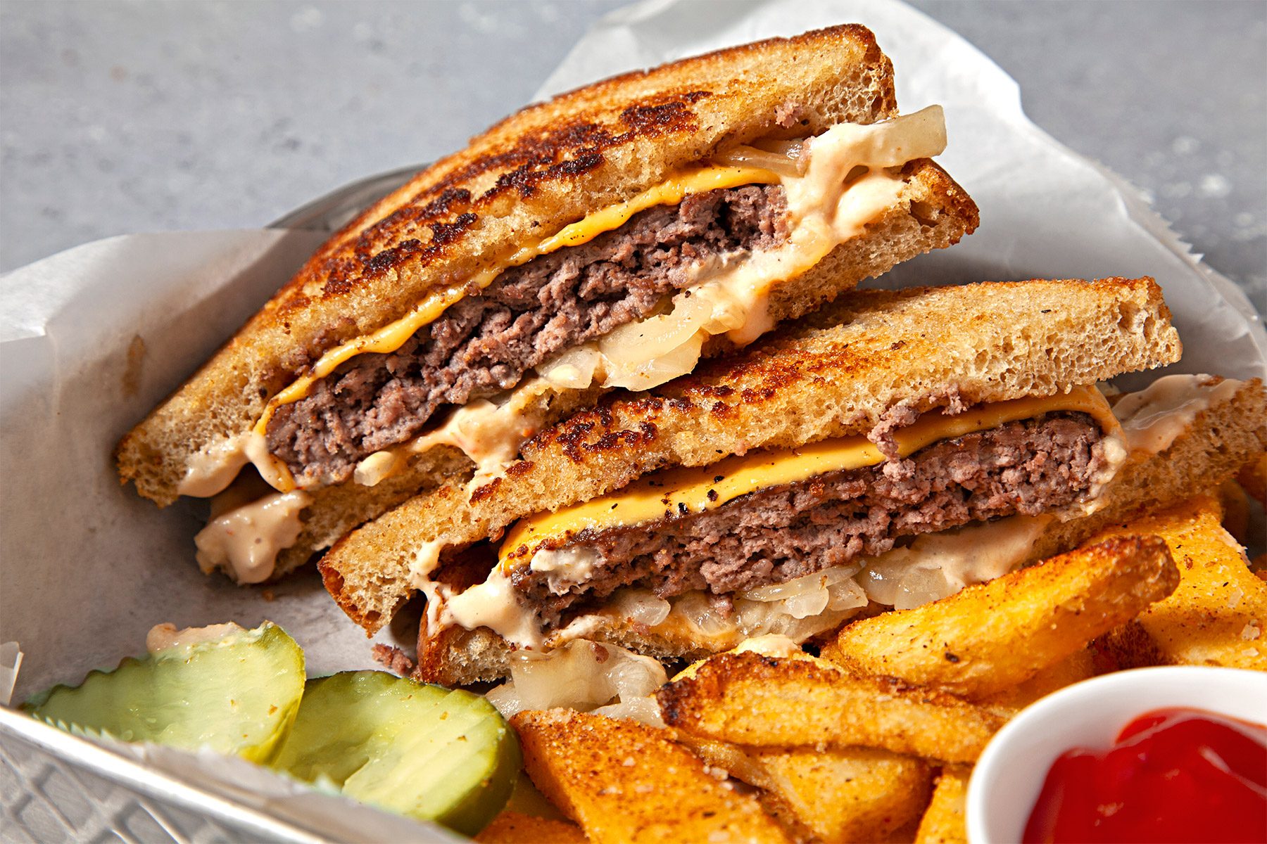 overhead shot; Patty Melts served with potato wedges and ketchup;