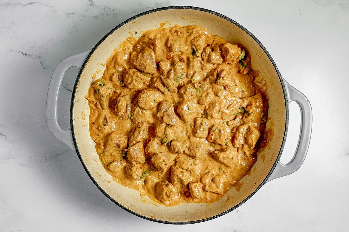 Taste of Home pork stroganoff in a ceramic skillet on a marble surface.