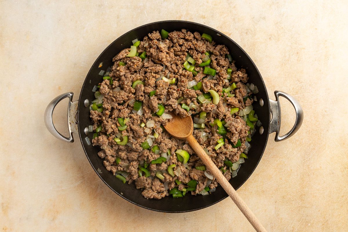 Taste of Home Sausage Rice Casserole recipe photo of the celery, green pepper, onion and sausage cooked in a large skillet.